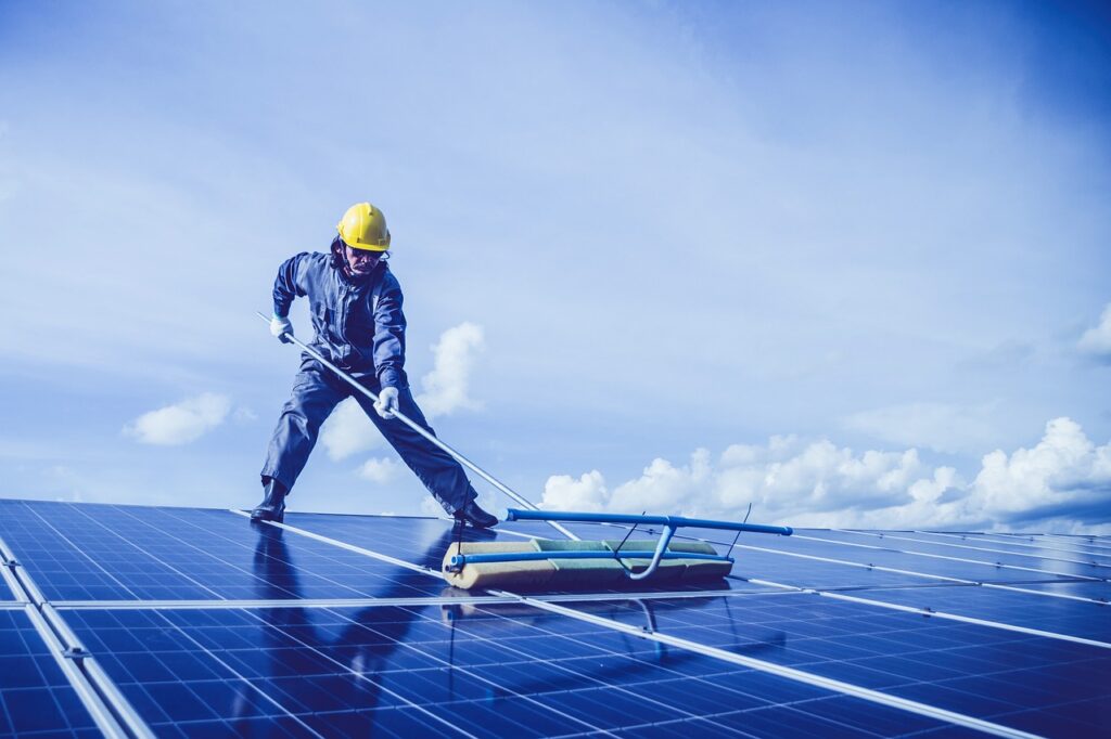 Profissional especializado realizado a limpeza do painel de energia solar fotovoltaica em casa 